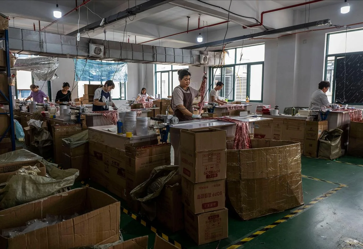 Workshop team preparing products beside stacks of packaging cartons