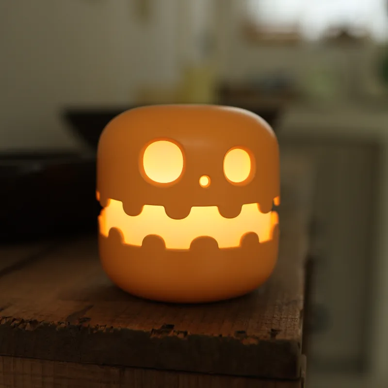 Glowing orange pumpkin-shaped mood lamp on a wooden surface