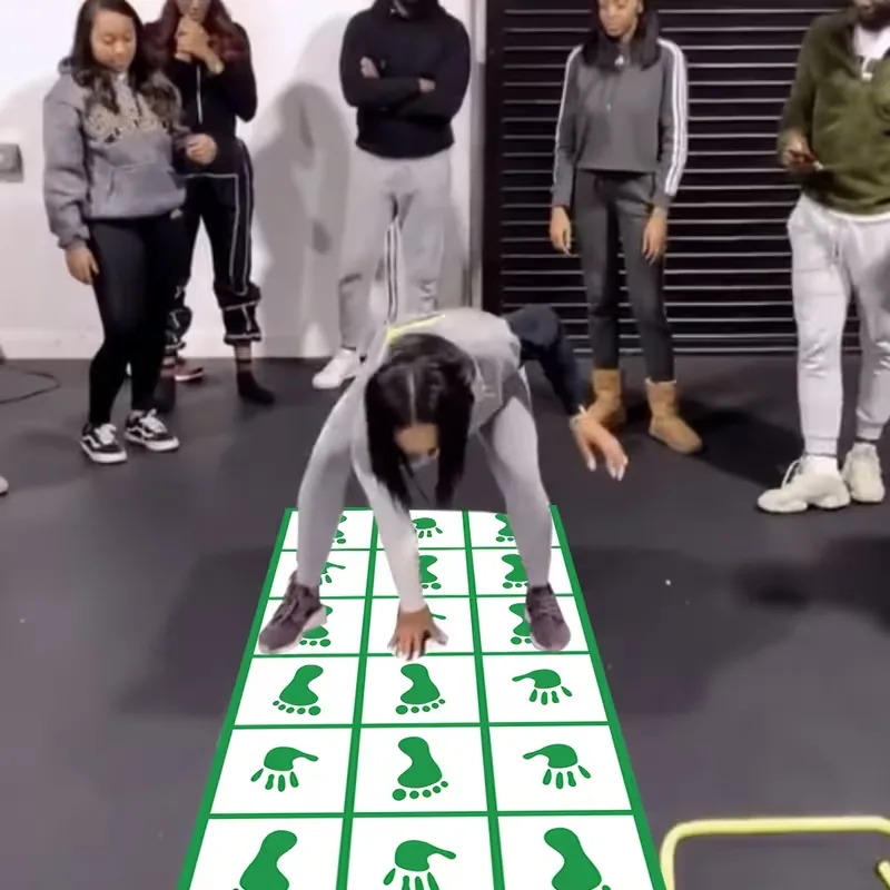 Group playing on a green hands and feet challenge mat