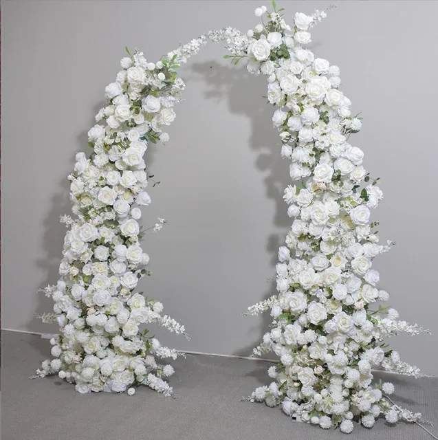 White floral arch arrangement photographed against a gray studio background