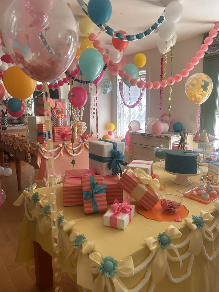 Colorful birthday party room with balloons, streamers, wrapped gifts and a decorated table